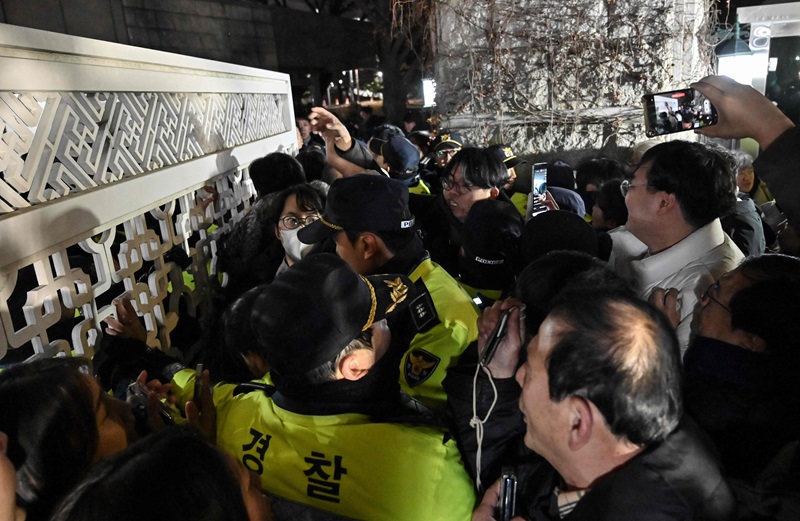 Police attempt to hold back people trying to enter the National Assembly afp.jpg